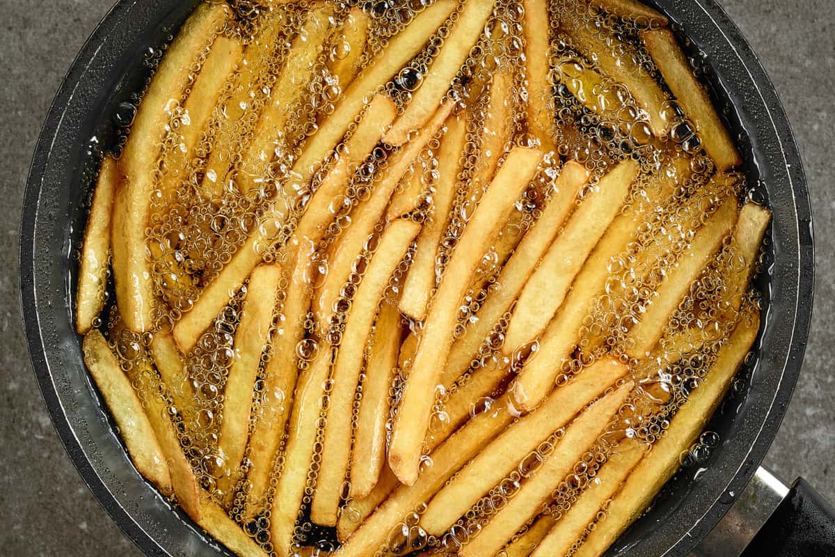 frying french fries in a pan with oil, top view